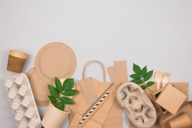 istock Eco-friendly sustainable packaging and tableware set - kraft paper food packaging on gray background with copy space. Street food paper packaging - cups, plates, straws, containers, paper bags 1337261849
