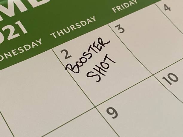 Booster Shot Scheduled on Calendar Writing appointment for COVID-19 vaccine booster shot on a calendar booster dose photos stock pictures, royalty-free photos & images