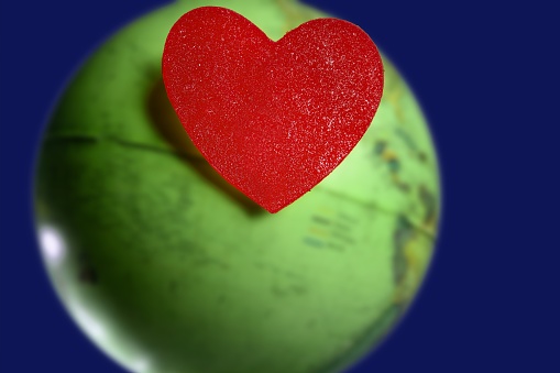 Red candy valentines heart over the world green global earth map