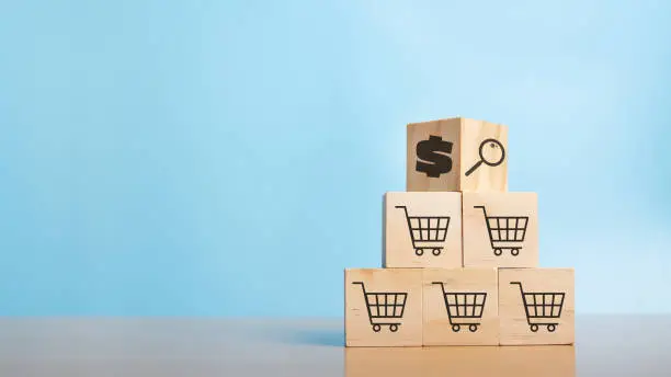 Photo of Wood cube stacking with coin dollar symbol and shopping cart symbol. Business growth success process. Business Concept. Shopping online. E-marketing.