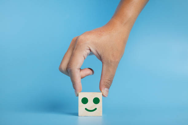 istock Hand holding wood cube with smiley face icon. Customer service rating, Satisfaction survey concept. 1337264609