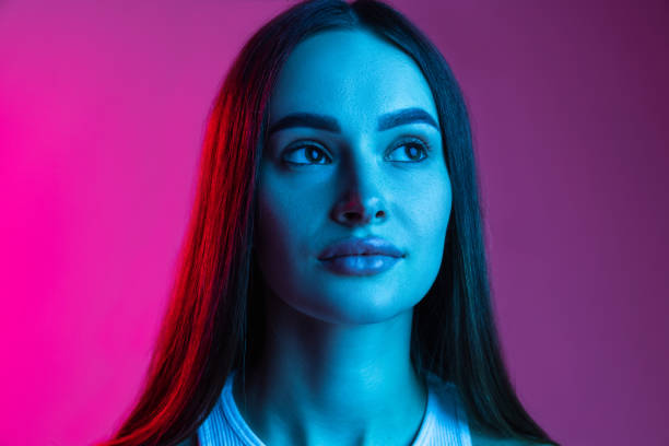 istock Dreamy looking young beautiful girl on gradient pink purple studio background 1337270635