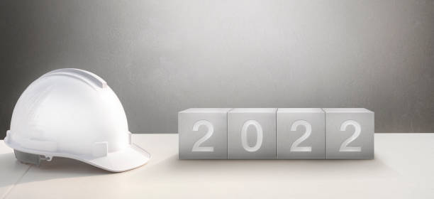 istock Happy New Year 2022 Construction and Industry. White Helmet and a numbered on concrete cube 1337272571