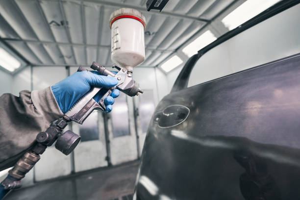 istock Auto workshop worker painting car door with spraying pistol 1337272783