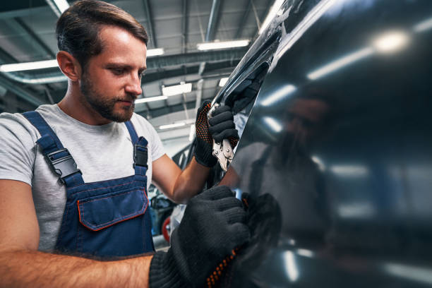 Auto mechanic using vice grip on car external detail