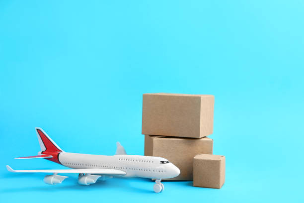 istock Airplane model and carton boxes on light blue background. Courier service 1337274610