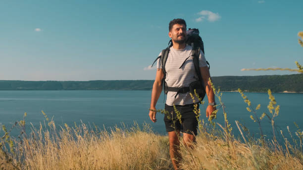 istock The handsome man walking with backpack along the coast 1337277980