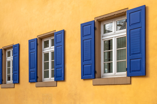 Blue wooden shuttered louvred windows isolated on white background.