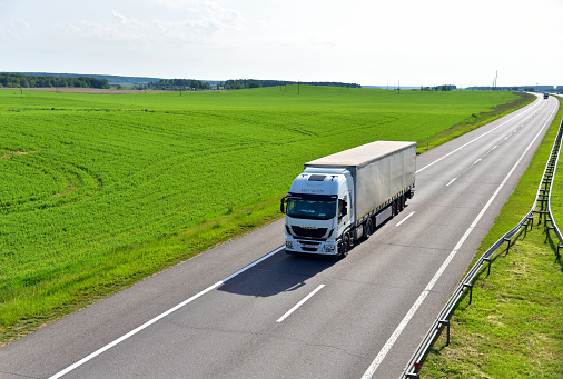 Truck IVECO with Semi-trailer driving along highway. Goods Delivery by roads. Services and Transport logistics. Russia, Moscow region, May 04, 2021