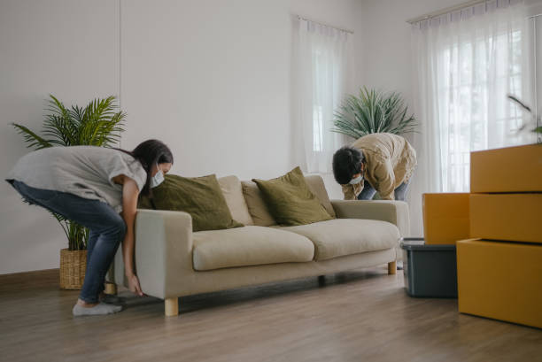 istock Couple carrying sofa in new house on moving day. 1337281047