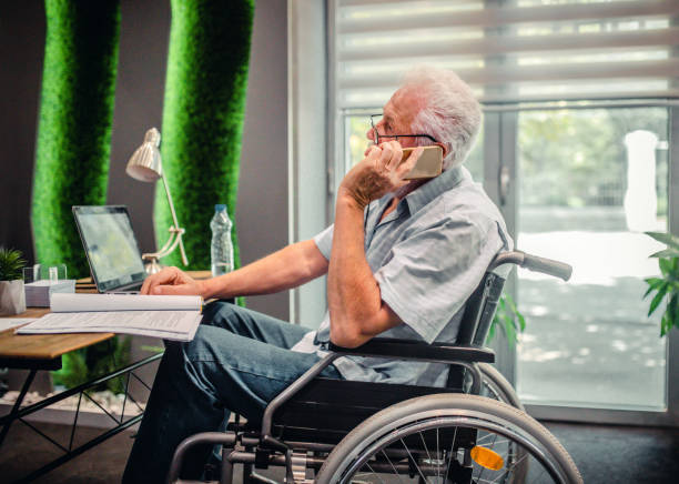 istock Disabled senior man in a wheelchair in a office 1337284076