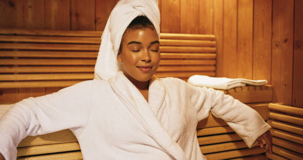 Shot of a beautiful young woman relaxing in a sauna at a spa You may be surprised at just how much you needed a moment of calm sauna stock pictures, royalty-free photos & images