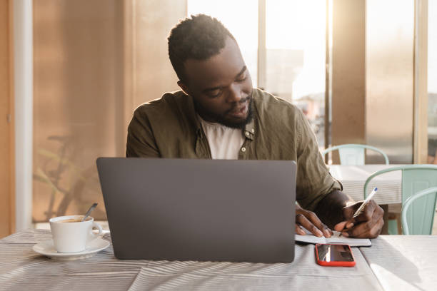 istock Business african american man using computer laptop working at bar restaurant - Focus on face 1337284953