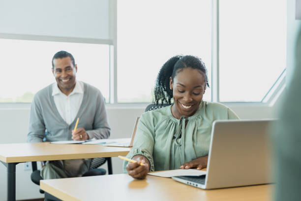 istock Two adult students in continuing education class smile during lecture 1337284985