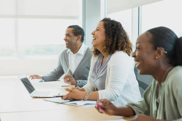 istock Adult colleagues smile and laugh during presentation 1337284992