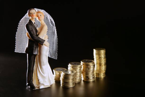 istock wedding couple figurine and golden coins 1337285100