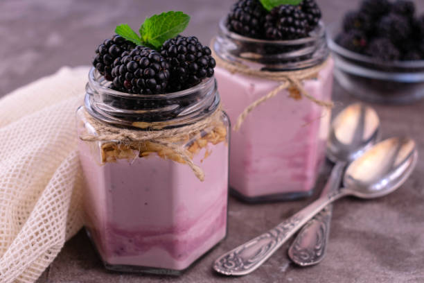 istock Yogurt with blackberries in jars on a gray background.Close-up. 1337286544