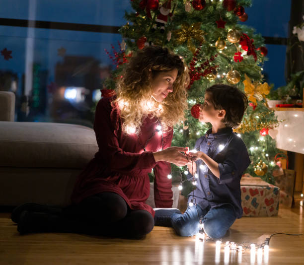 istock Happy mother decorating the Christmas tree with her son 1337288263
