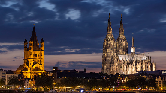 Cologne, Germany - Aug 23th 2021: Cologne skyline is spectacular with illuminated historical buildings next to Rhine river.