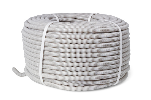 Coil of non-combustible corrugated hose for laying electrical wiring isolated on white background