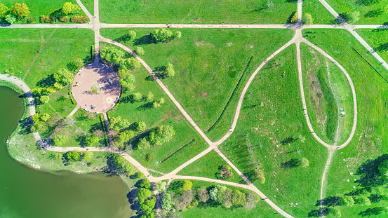 Pedestrian and bicycle paths in the bright green summer park. Aerial panoramic view