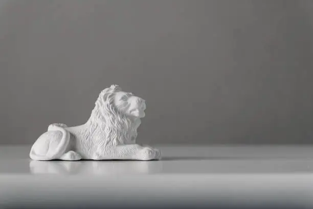 Photo of Toy lion figurine made of white plaster for painting with paints