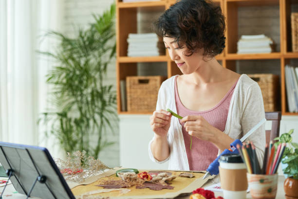 istock Woman Attaching Dried Flowers to Canvas 1337299701