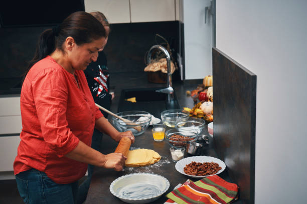 istock Mother and Teens Preparing Pecan Pie for the Holidays 1337301057
