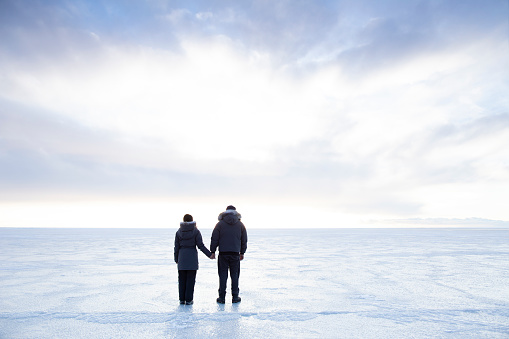 Young couple standing on ice embarking on an adventure in Iceland.