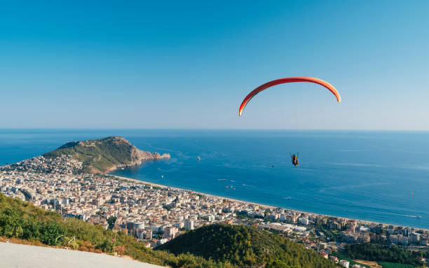 Tandem Paraglider flying in the sky above the Alanya City Aerial view of Alanya alanya stock pictures, royalty-free photos & images
