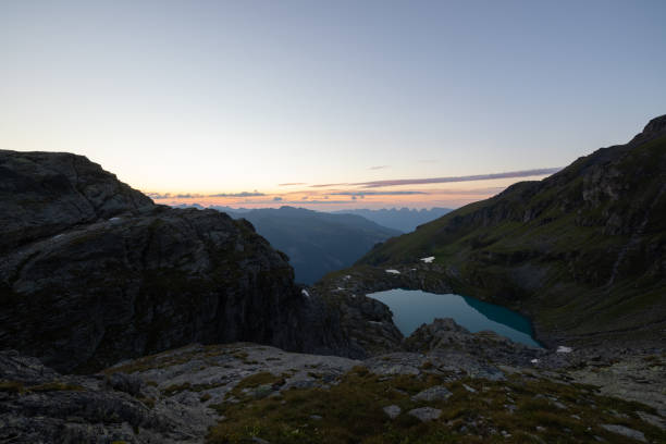 maravilloso paisaje en un lago alpino llamado wildsee en el cantón de san galo. atardecer épico en los alpes de suiza. hermosa vista con la tienda de campaña en frente y un día de campamento perfecto. - switzerland hiking boot outdoor pursuit recreational pursuit fotografías e imágenes de stock