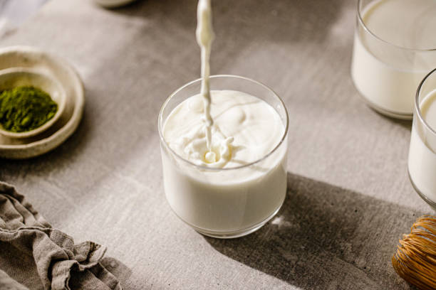 Pouring fresh milk in glass stock photo