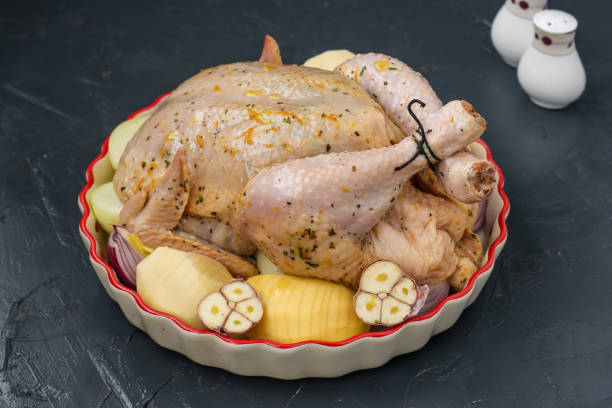 istock Raw chicken in a ceramic form in an orange-honey marinade with potatoes is preparing for baking in the oven, dark background, horizontal orientation 1337307357