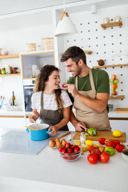 istock Happy young couple have fun in modern kitchen while preparing fresh food 1337309481
