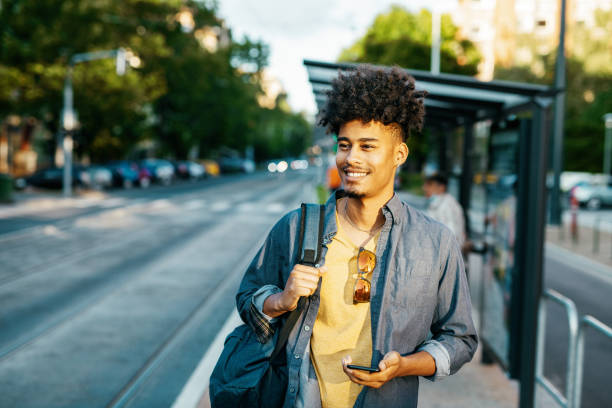 istock African American millennial man in downtown, using mobile phone and waiting for tram 1337310152