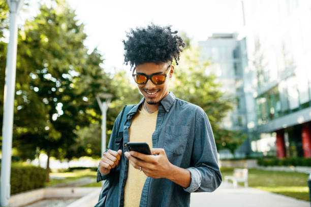 istock Mixed race millennial man in downtown with sunglasses using smart phone 1337310555