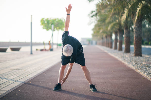 istock Senior man stretching on a running track before jogging 1337316080