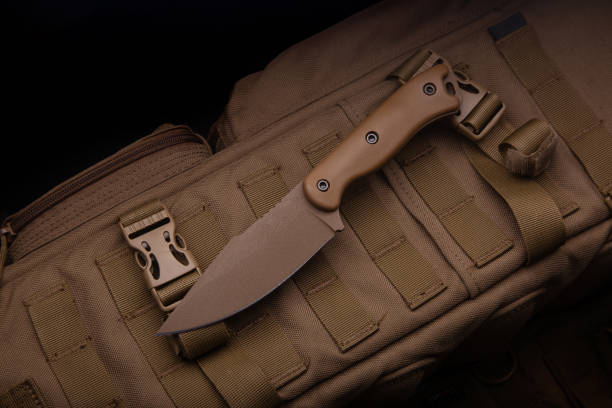 istock A modern military knife and a plastic sheath for it. Edged weapons lie on a desert-colored military backpack. 1337316324