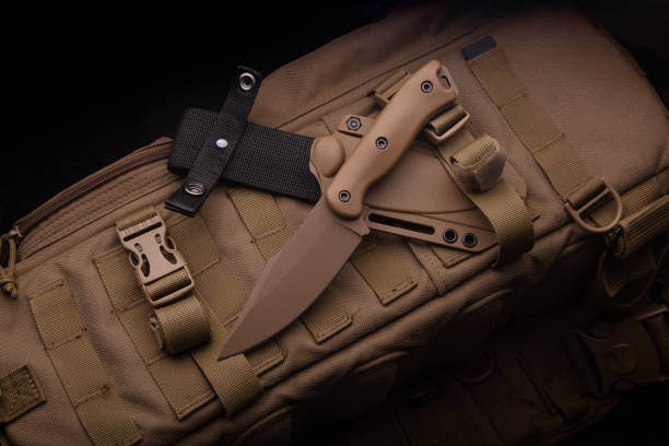 istock A modern military knife and a plastic sheath for it. Edged weapons lie on a desert-colored military backpack. 1337316328