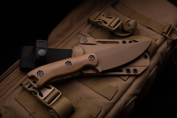 istock A modern military knife and a plastic sheath for it. Edged weapons lie on a desert-colored military backpack. 1337316332