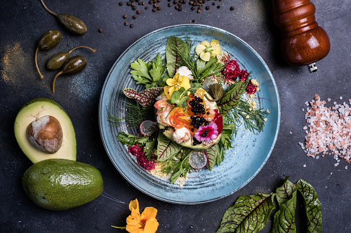 Fresh shrimps, avocado, caviar salad with lettuce green mix.