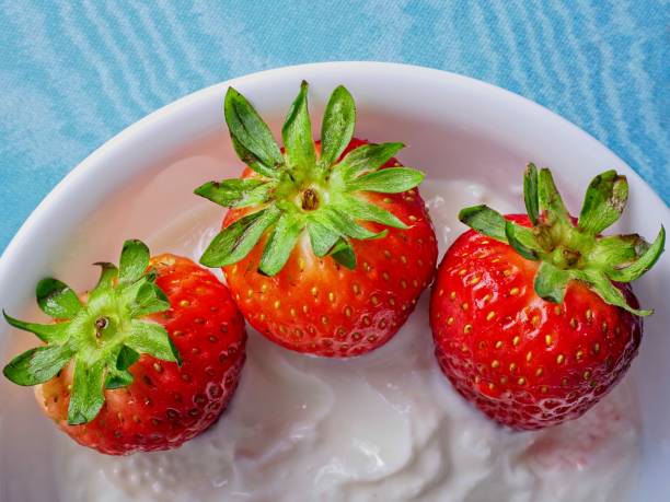 Fresh bright red strawberries with Greek yogurt in a bowl