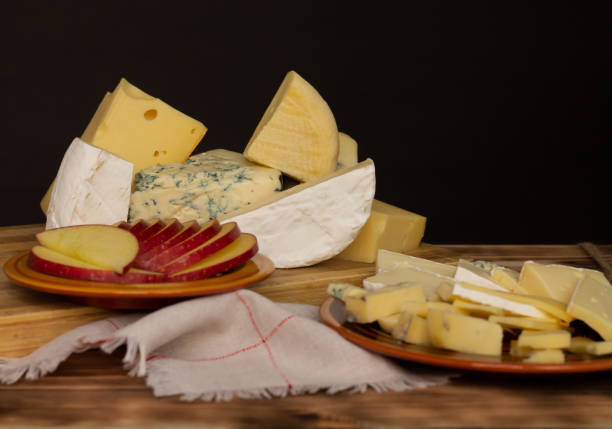 istock Different types of cheese on a rustic wooden cutting board on a dark background. Copy space. 1337327137