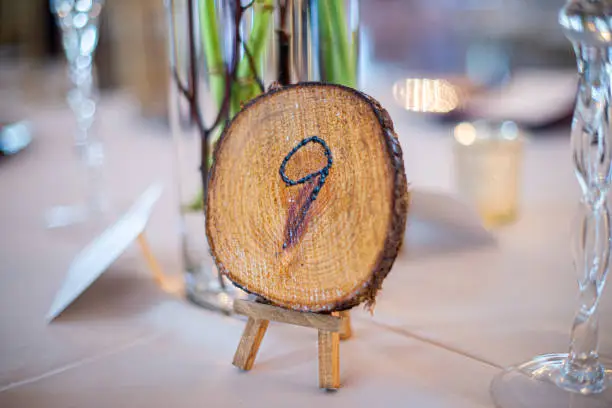 Wood stump with number nine engraved on it table place indicator at wedding recetion table