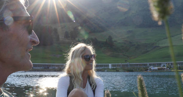 istock Couple pause by lake edge in conversation, mountains 1337332260
