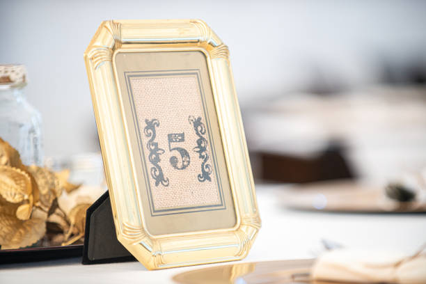 istock Wedding Reception table number Five place card in an elegant gold frame at wedding reception table setting 1337332790