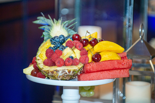 Assorted fruit platter with pineaple, watermelon, cherries, berries, blueberries and stawberries at desset bar