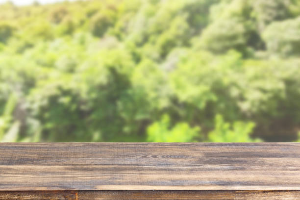istock wood table top on blur tree and green foliage background 1337333068