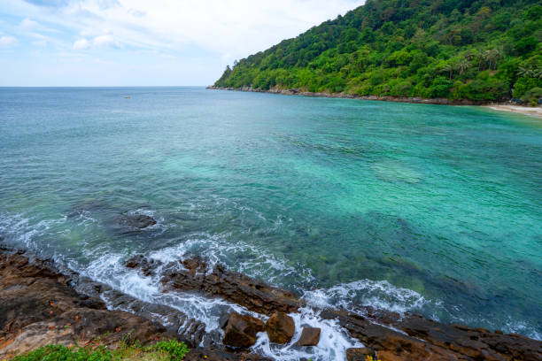 istock Rocky seashore under clear blue sky with clouds sea surface background Beautiful Sea and small island in Phuket Thailand. 1337333874