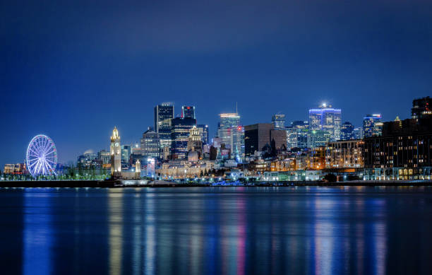 view of downtown and the old port of Montreal at night view of downtown and the old port of Montreal at night, with the Ferris wheel and the clock tower. ferris wheel stock pictures, royalty-free photos & images